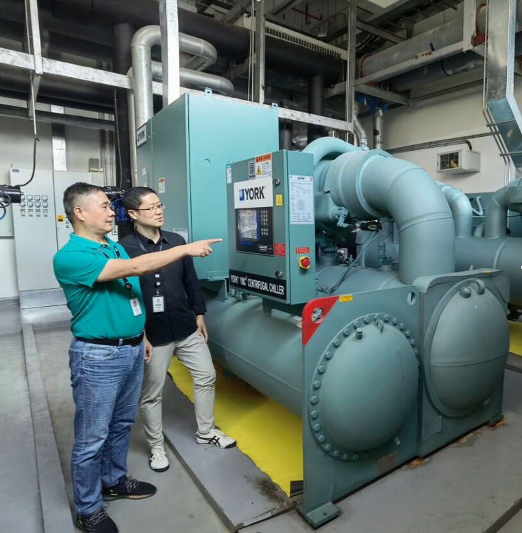 Two Gore Associates in front of a heat pump